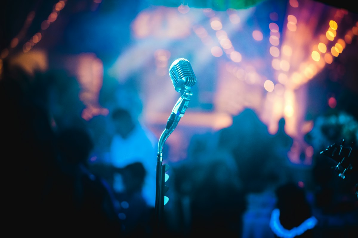 Stage lights at a dark venue, warm glow across the floor